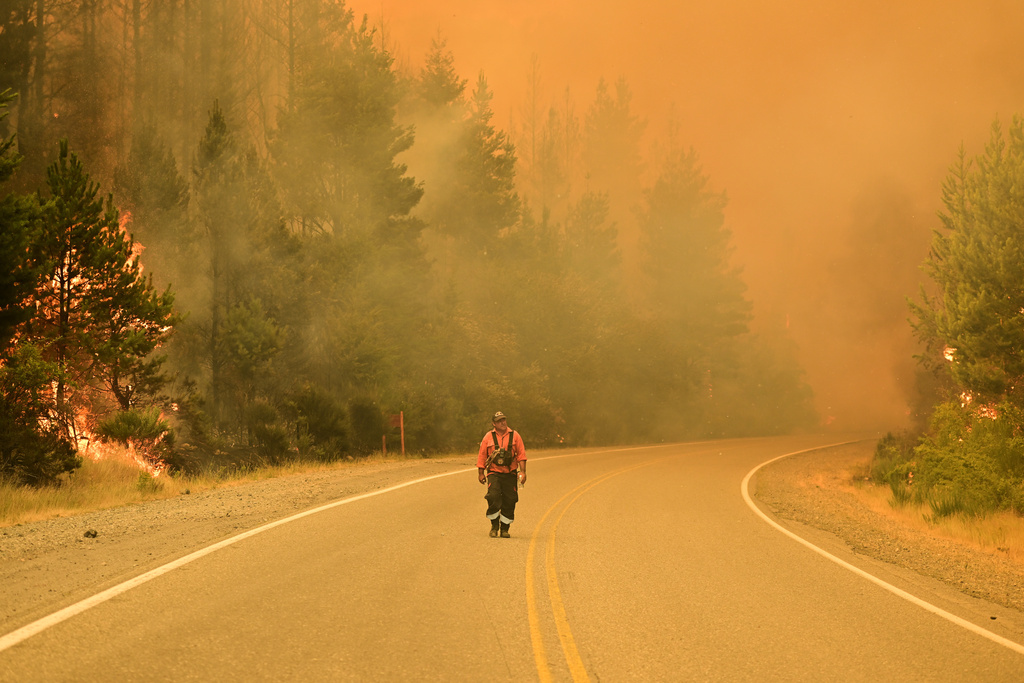 un bombero camina por una carretera mientras los incendios forestales arden en El Hoyo, Patagonia, Argentina, el jueves 8 de enero de 2026. Foto: AP/Maxi Jonas